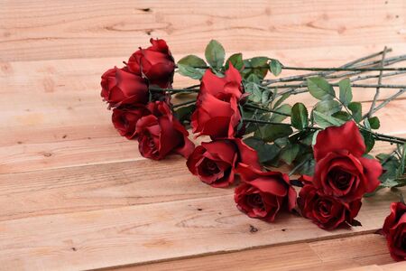 A bouquet of red roses on a wooden .の写真素材