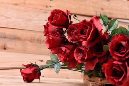 A bouquet of red roses on a wooden background.の写真素材