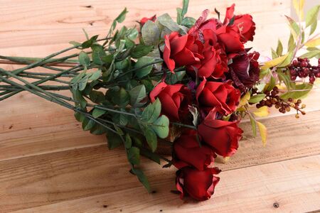 A bouquet of red roses on a wooden background.の写真素材