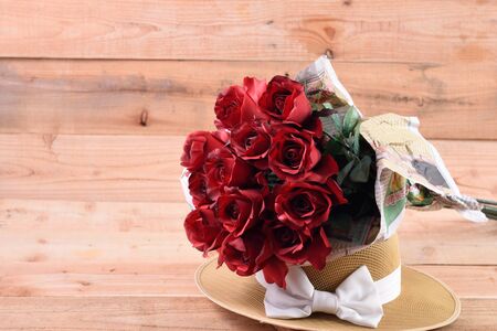 A bouquet of red roses on a wooden background.の写真素材