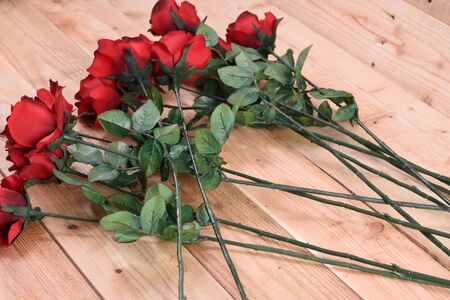 A bouquet of red roses on a wooden background.の写真素材