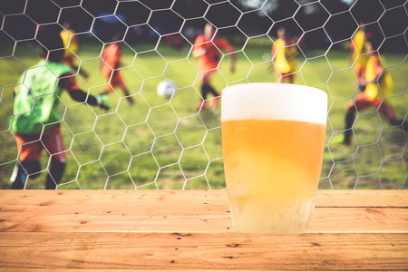 A glass of beer rests on a wooden floor.の写真素材