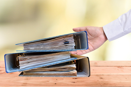a file folder with documents and important document,On a wooden backgroundの写真素材