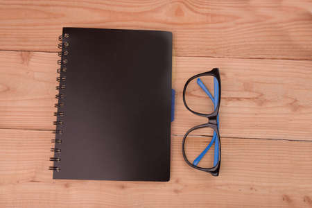 books and eyeglasses,on wood Backgroundの写真素材