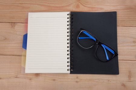 books and eyeglasses,on wood Backgroundの写真素材