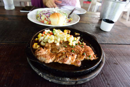 pork steak,Steak hot pan on wood background.の写真素材