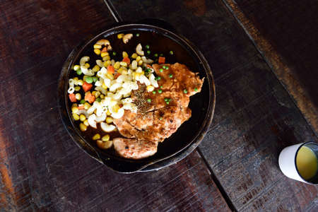 pork steak,Steak hot pan on wood background.の写真素材