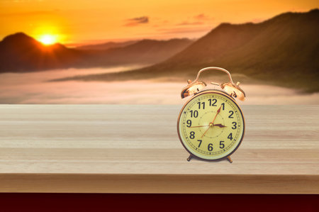 Retro alarm clock,Put on the table back into Mountain sunsetの写真素材