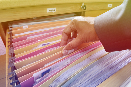 Hands Businessman searching through file folders with personal finance documentsの写真素材