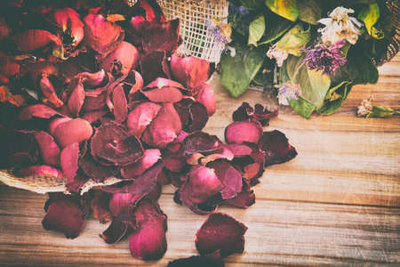 abstract rose,Dry red rose petals dark tone on wood backgroundの写真素材