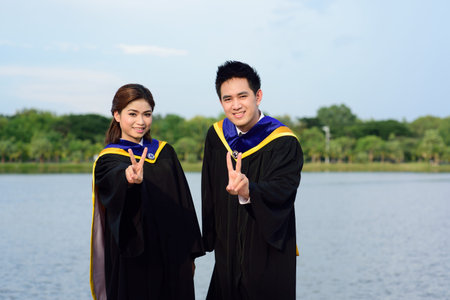 Happy graduated student guy and girl at graduation ceremony