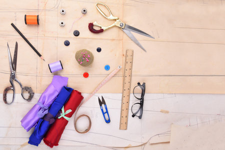 Fashion design ,Tools for sewing on wooden background Top view.