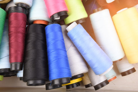 Fashion design multicolor sewing threads on wooden background