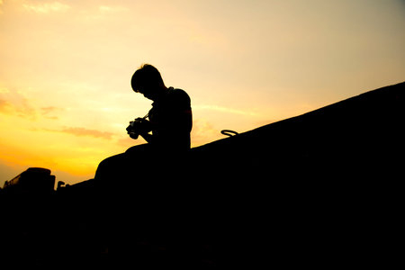 Silhouette Sunset,Photographer checks camera files.