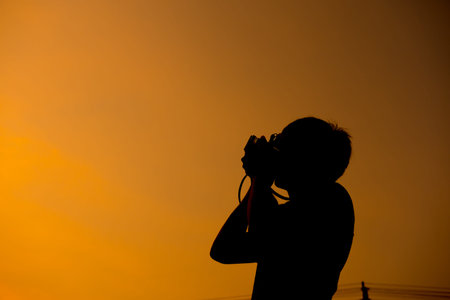 Silhouette Sunset,Photographer checks camera files.の写真素材