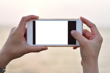 The tourists hold the phone to take pictures.の写真素材