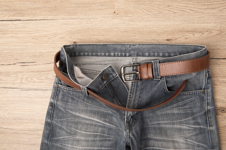 Top view Jeans and leather belt pace on wooden background.の写真素材