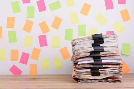 Stacked documents on the office desk,Colorful paper note the background