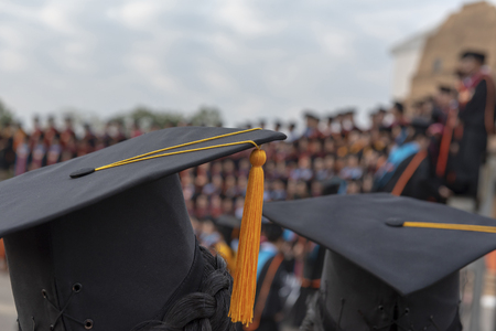 Back of graduation with black yellow tail cap at ceremony in graduation in the University.の写真素材