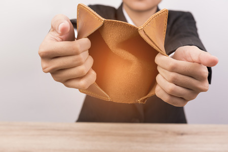 Close up of hand opens an empty wallet on wooden background.の写真素材