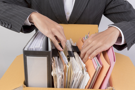 Working women holding documents clipping black clips in front.の写真素材