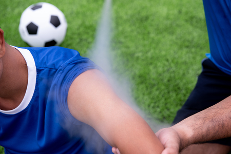 Footballer wearing a blue shirt, black pants injured in the lawn during the race.の写真素材