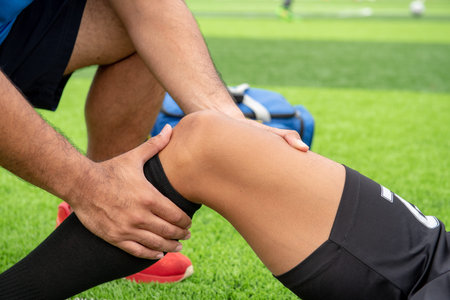 Footballer wearing a blue shirt, black pants injured in the lawn during the race.