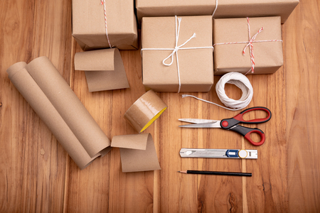 Brown padded package with brown paper laid on wooden floor.の写真素材