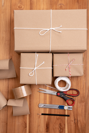 Brown padded package with brown paper laid on wooden floor.の写真素材