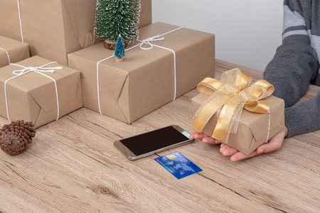 Christmas gift box wrapped in brown paper on Christmas day, laid on wooden floor.の写真素材