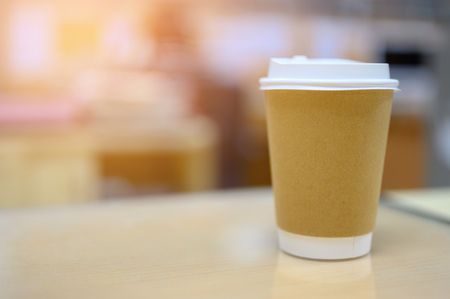 A cup of coffee on wooden table ready to take away for drink.の写真素材