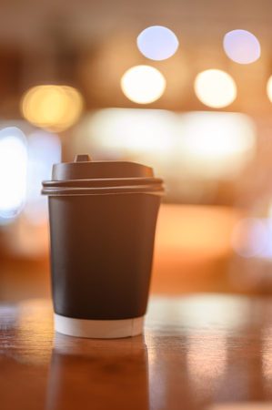 A cup of coffee on wooden table ready to take away for drink.の写真素材