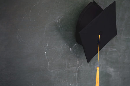 Black graduates hat hung on the blackboard
