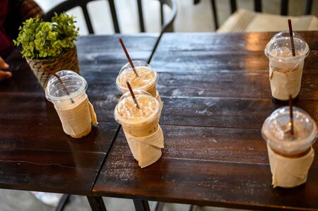 Many coffee mugs are placed on a wooden table at a coffee shop.の写真素材
