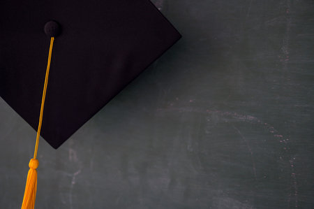Black graduates hat hung on the blackboard