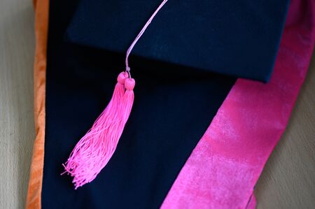 Graduation cap, black, yellow tassel, put on a black dress.の写真素材