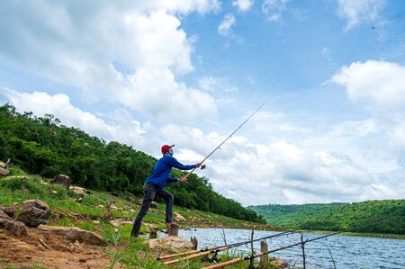 Fisherman with Fishing Rod on reservoirの写真素材