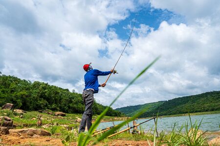 Fisherman with Fishing Rod on reservoirの写真素材