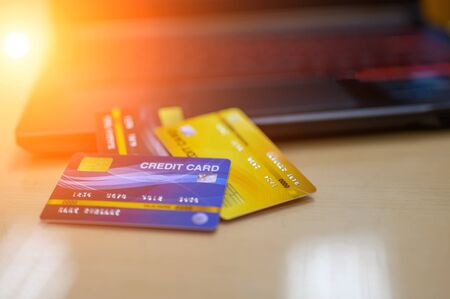 Credit cards and notebook computers are placed on the desk.の写真素材