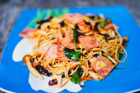 Stir fried spaghetti on a plate on a wooden floor.の写真素材