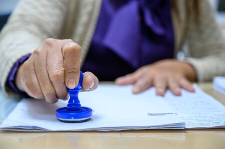 The staff stamped the documents at the office table.の写真素材