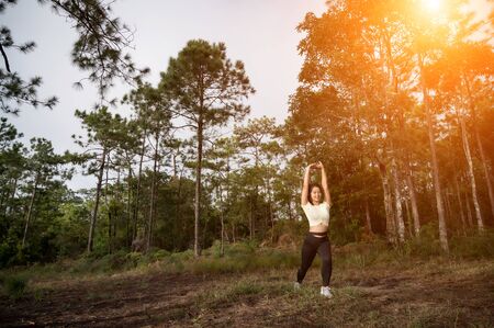 A woman running trek at a mountain pine forest.の写真素材