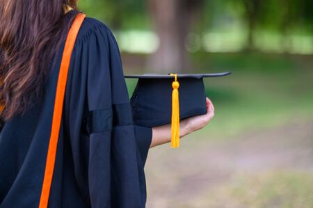 Graduates wear black academic gown on the day of graduation at the university.の写真素材