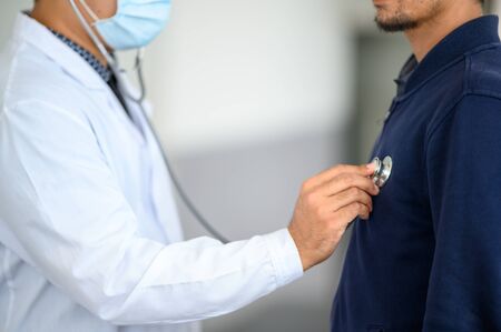 Portrait male doctor wearing a white glue, preparing to check the patientの写真素材