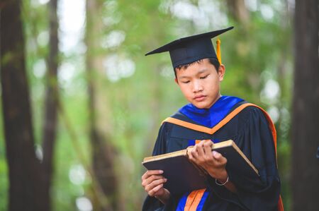 A graduate student sitting and reading a bookの写真素材