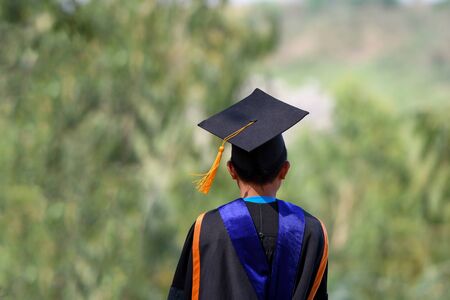 Asian students wore black frilly suits, black hats, yellow tassels on graduation day.の写真素材