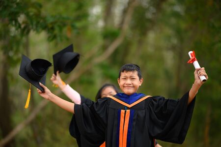 Asian students wore black frilly suits, black hats, yellow tassels on graduation day.の写真素材