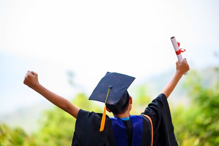 Asian students wore black frilly suits, black hats, yellow tassels on graduation day.の写真素材