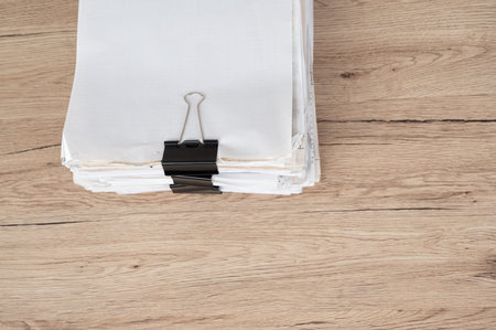 A black document clip that attaches to a desk.