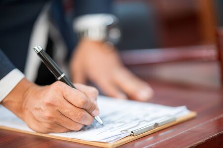 The lawyer is carrying a pen to write a case record in the courtroomの写真素材